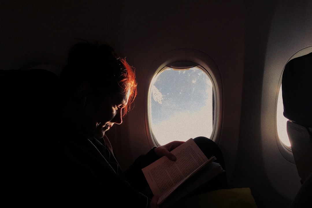 Woman reading book in airplane